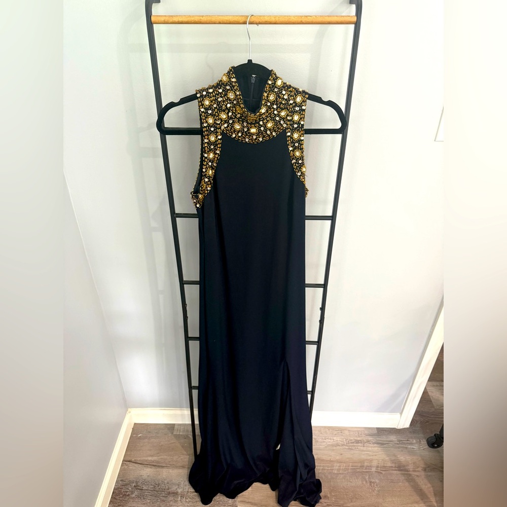 This is an elegant black sleeveless gown with a high neckline.